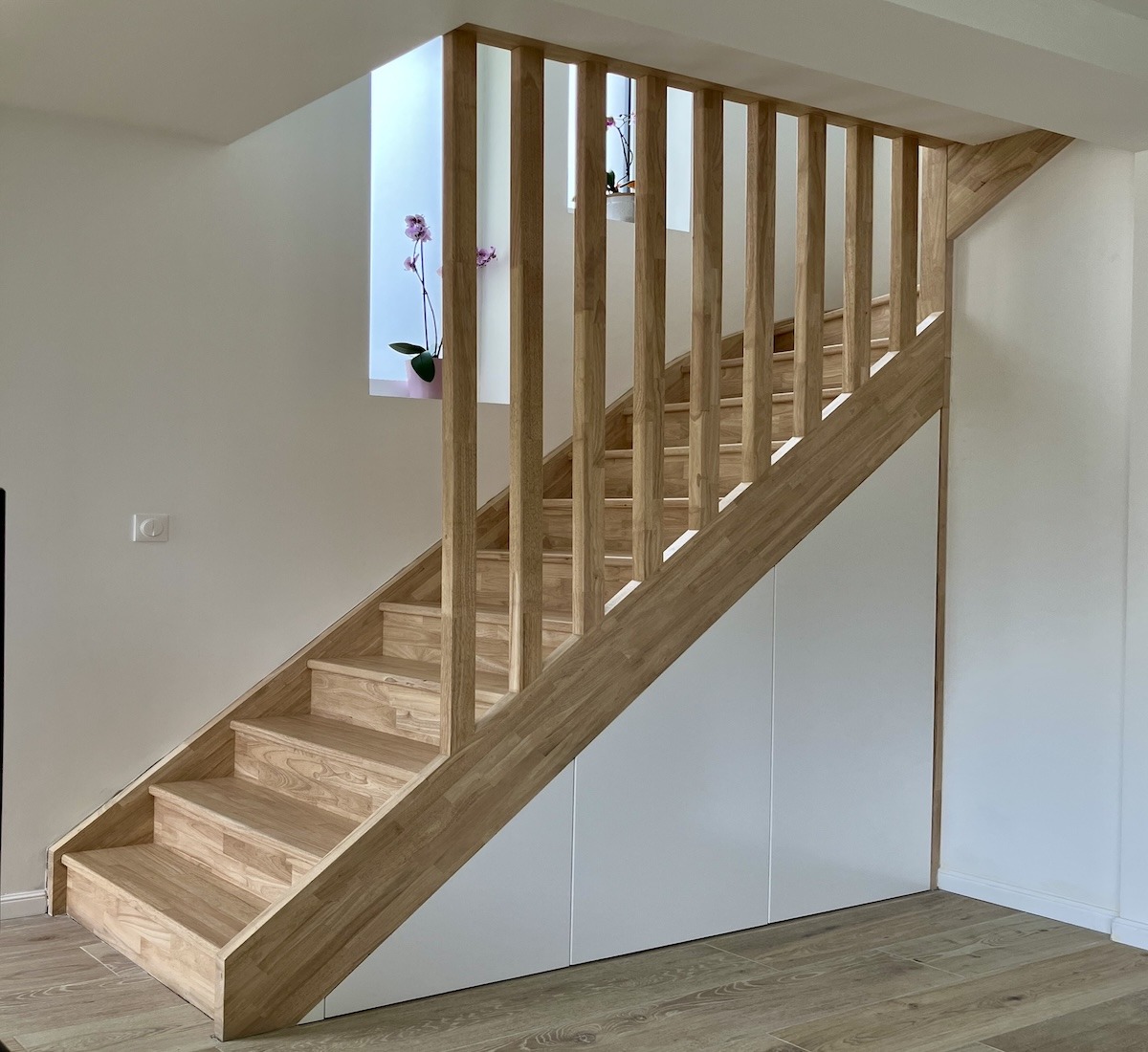 placards sous-escalier sur-mesure avec rangement intégrés et claustra en hévéa massif réalisés dans une maison à Ermont dans les Yvelines