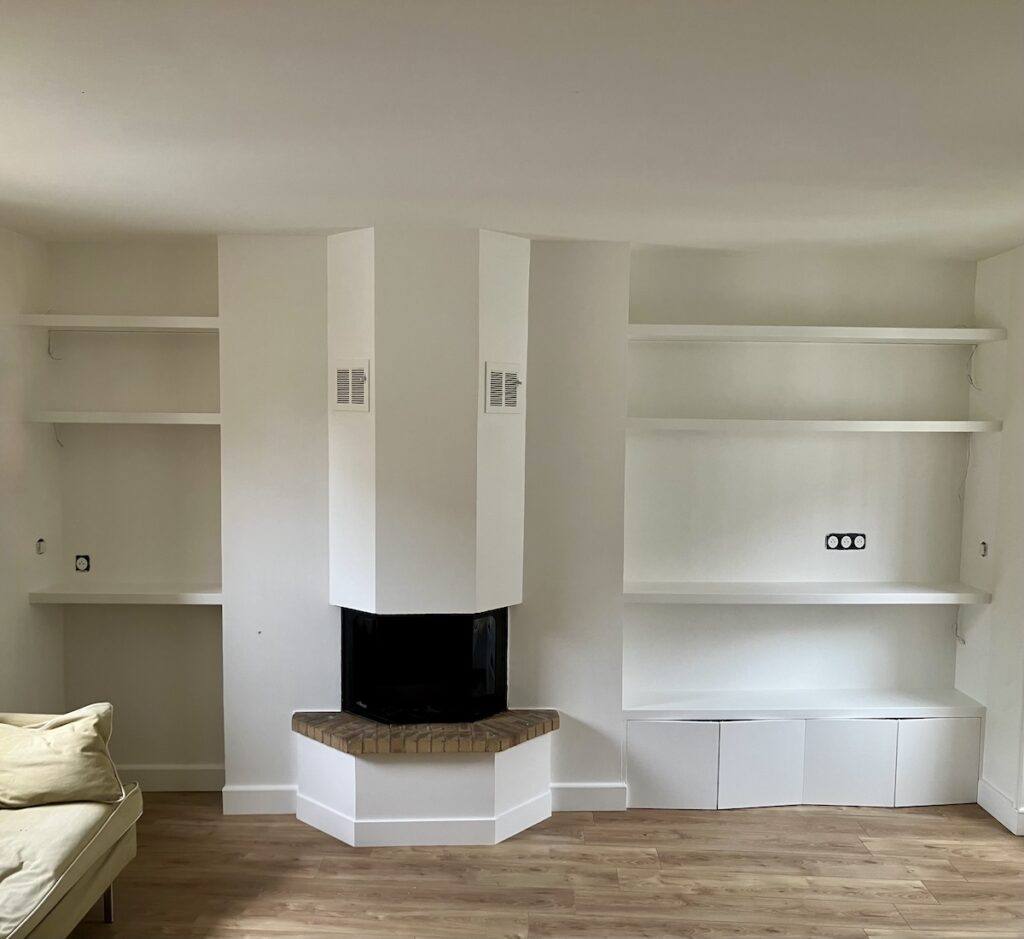 Meuble TV sur mesure avec placards intégrés et bibliothèque encastrée autour d'une cheminée, réalisé dans un appartement à Levallois-Perret (92)