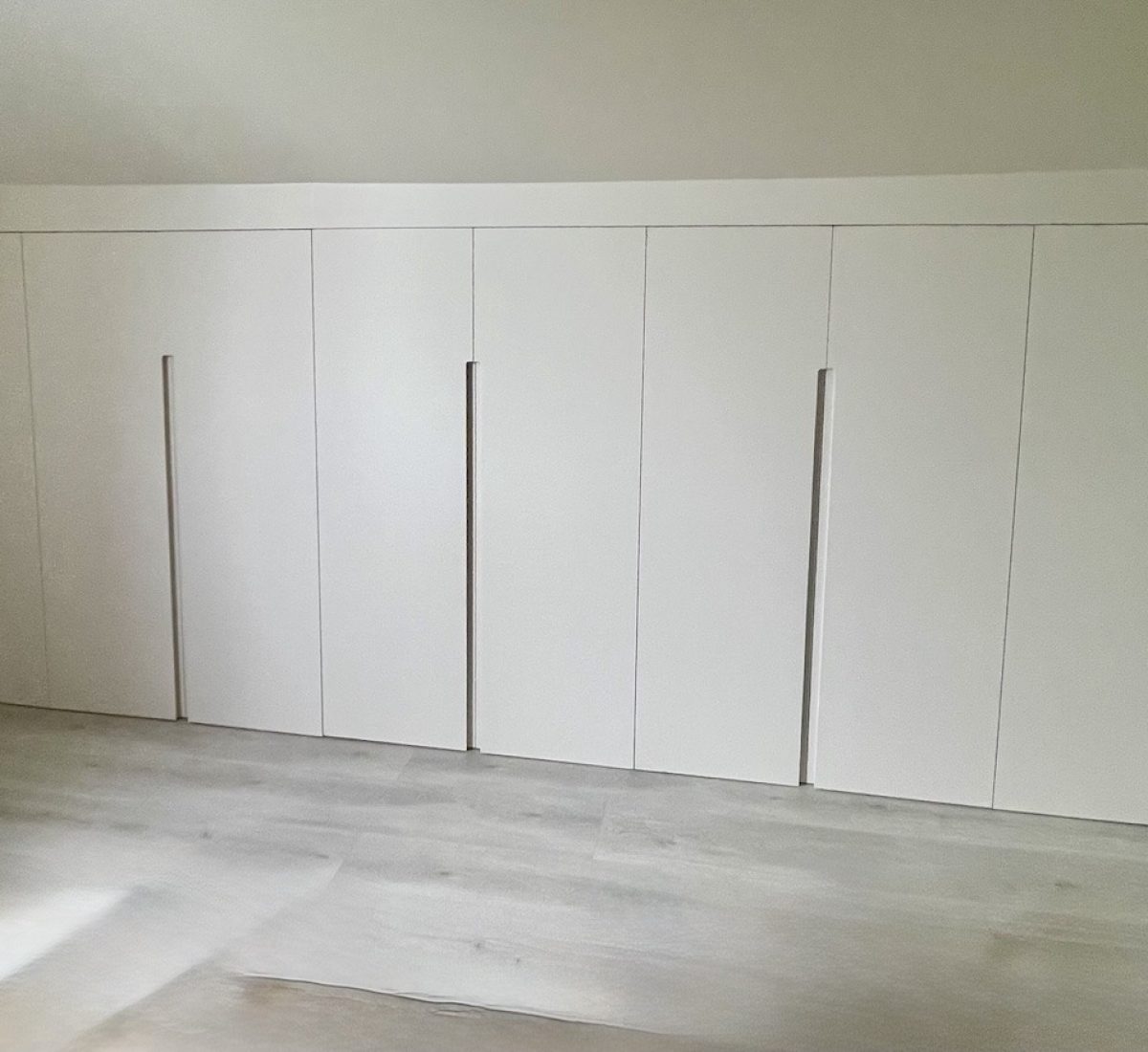 Dressings sous pente sur mesure avec finition peinture dans une chambre mansardée à Croissy‑sur‑Seine.
