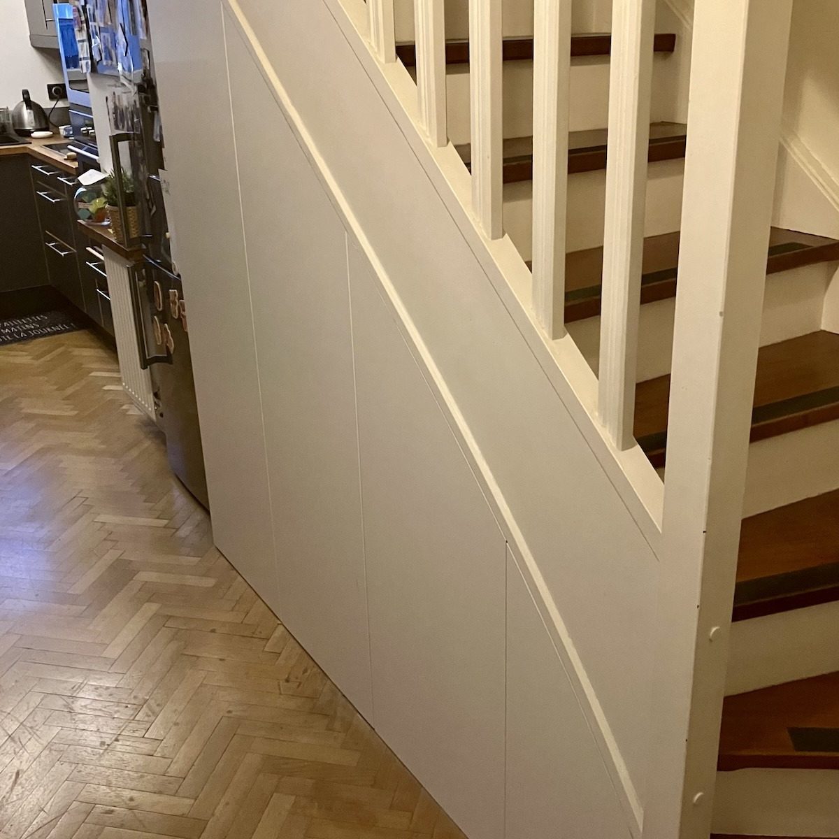 Placards sur mesure encastrés, réalisés sous un escalier dans un appartement à Courbevoie (92)