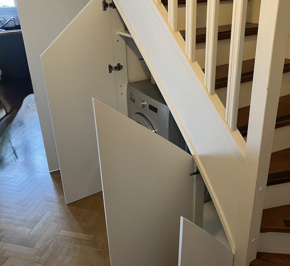 agencement sur mesure sous-escalier composé de placards encastrés et portes personnalisées dans un appartement à Courbevoie dans les Hauts-de-Seine