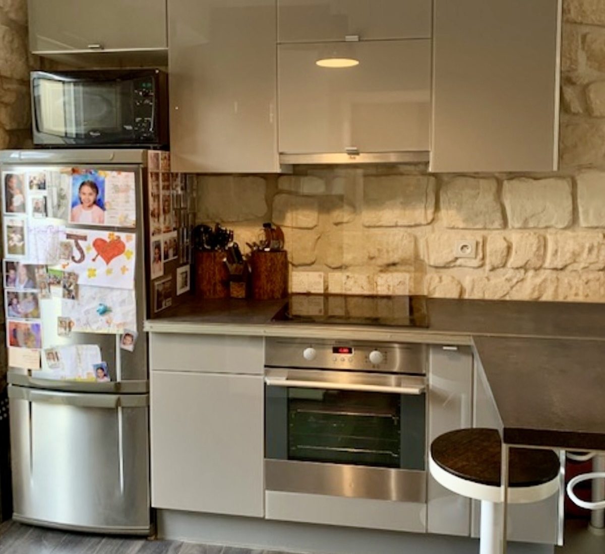 Pose cuisine sur mesure avec façades en verre sur mur en pierres naturelles à Bois‑Colombes.