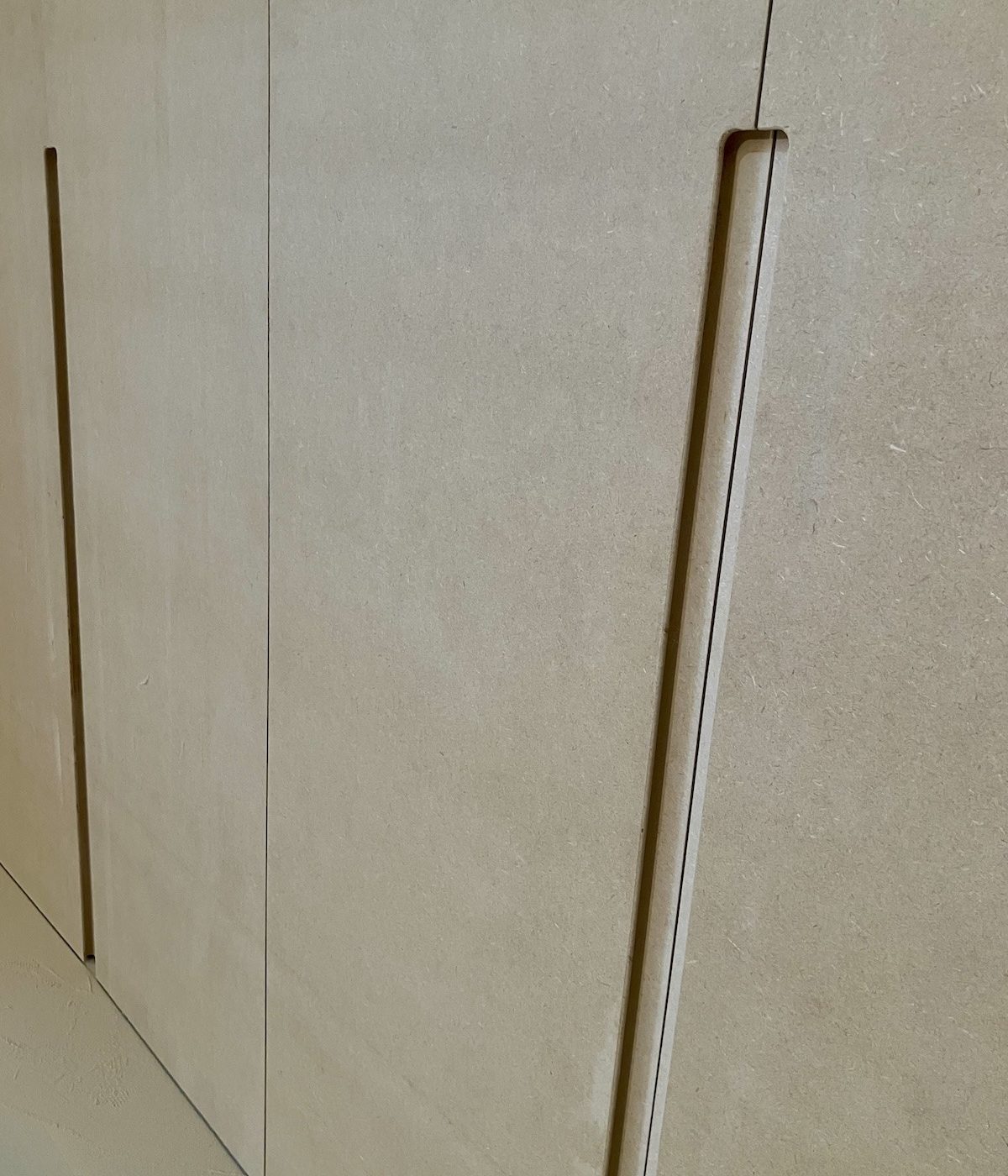 Détail de l’usinage des poignées intégrées sur mesure pour les portes de dressing en MDF à Croissy‑sur‑Seine.